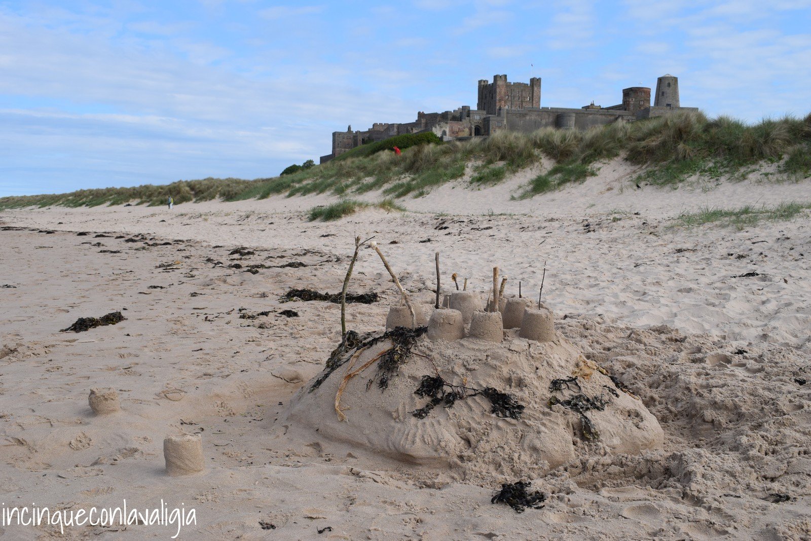 Castelli di sabbia con il castello di Bamburgh sullo sfondo Castelli di sabbia con il Castello di Bamburgh